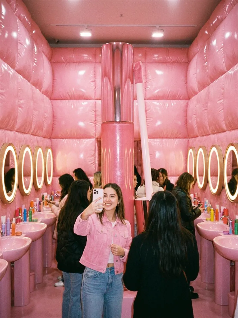 Millennial-pink beauty pop-up environment with giant lip gloss sculpture